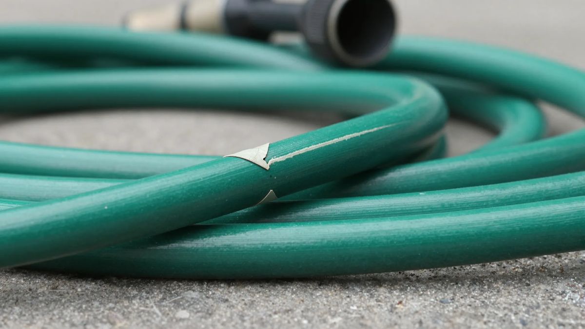 Vinco marcado na parede de uma mangueira de jardim, com a marca clara atravessando o tubo
