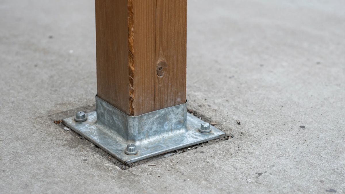 Base de pilar de madeira de pergolado apoiada em sapata metálica que a levanta do piso