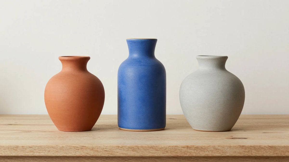 Três vasos decorativos lado a lado: um de barro, um de cerâmica esmaltada azul e um claro fosco